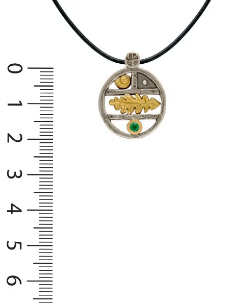 Pendentif en argent, rond en forme d'étagère sur laquelle sont disposés des motifs en or coquillage et feuille ainsi qu'une emeraude